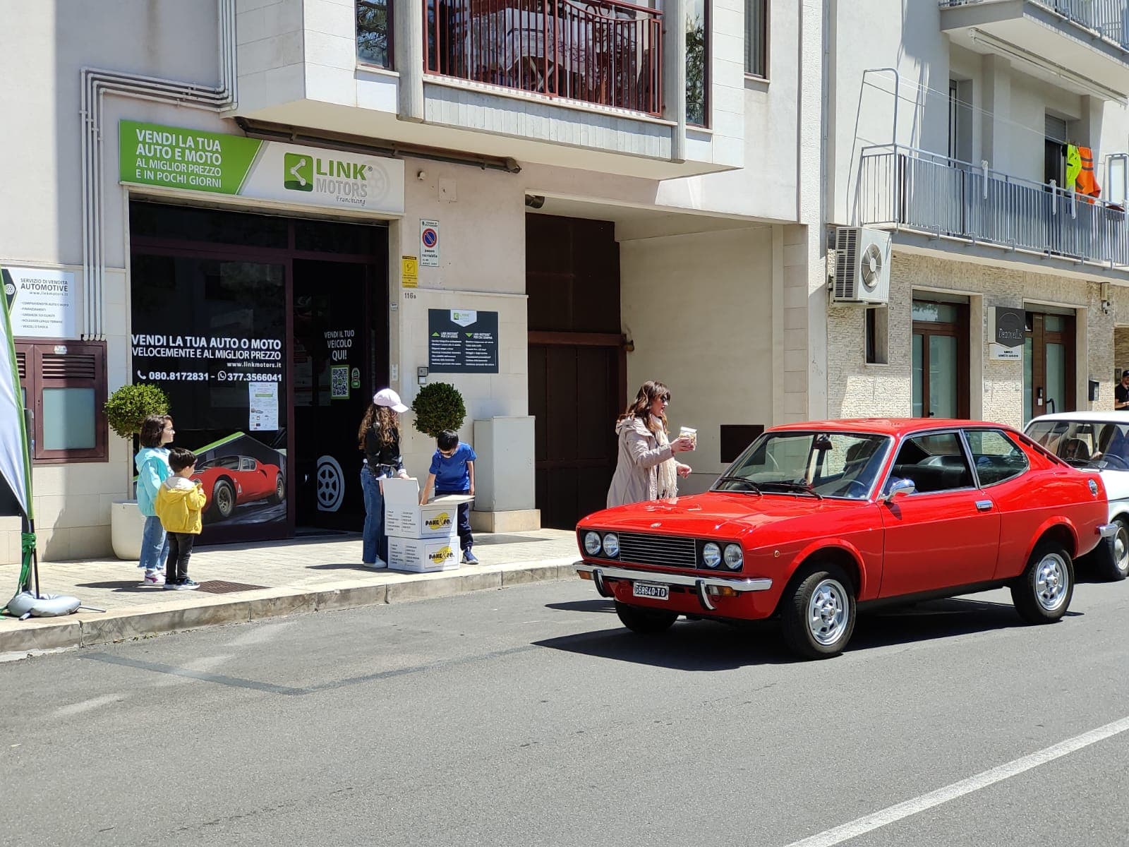 Coupé rosso d'epoca esposto durante il raduno Link Motors Club
